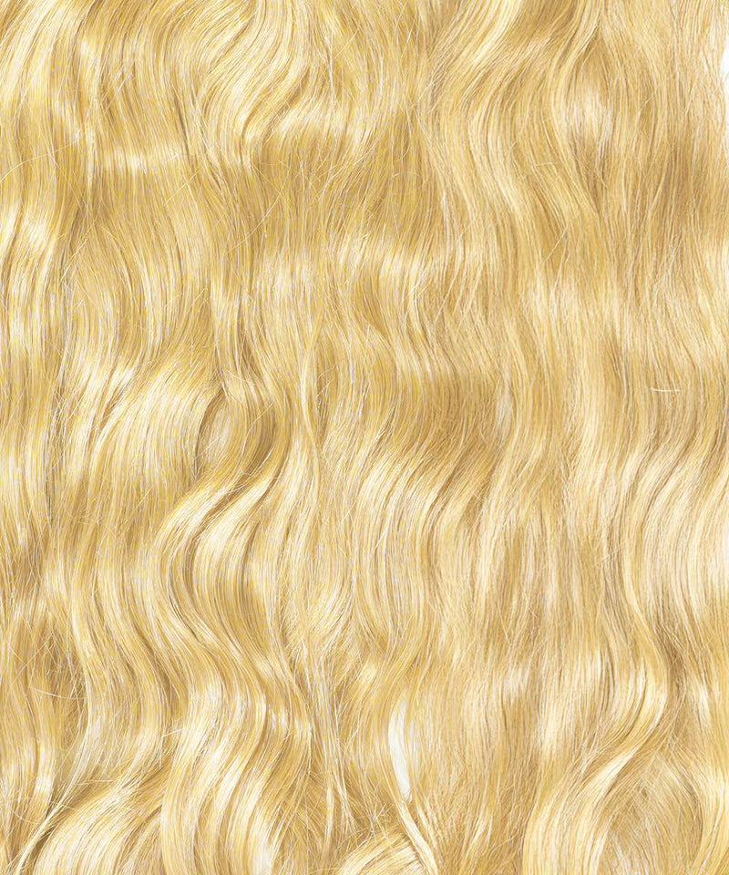 Close-up of long, wavy, shiny hair with soft waves and rich Warm Mocha Lowlights (2/4/6), enhanced by Perfect Locks Wavy Clip-In Ponytail Extensions.
