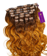 Wavy Seamless Clip-In Hair Extensions by Perfect Locks in pumpkin gold, with multiple wefts and a purple Perfect Locks tag.#color_pumpkin-gold-(33/55)