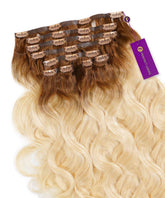A set of Perfect Locks Wavy Seamless Clip-In Hair Extensions in Rooted Golden Blonde (4/22), laid flat with clips and a purple Perfect Locks tag.#color_rooted-golden-blonde-(4/22)