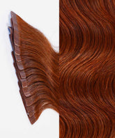 Close-up showing Perfect Locks Wavy Classic Tape-In Hair Extensions in Dark Auburn; adhesive wefts left, smooth hair right.