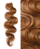 A long, wavy lock of Perfect Locks Wavy Seamless Tape In Weft in Golden Brown is on the left; right shows a close-up of its shiny, smooth texture and defined waves.#color_golden-brown-(6)