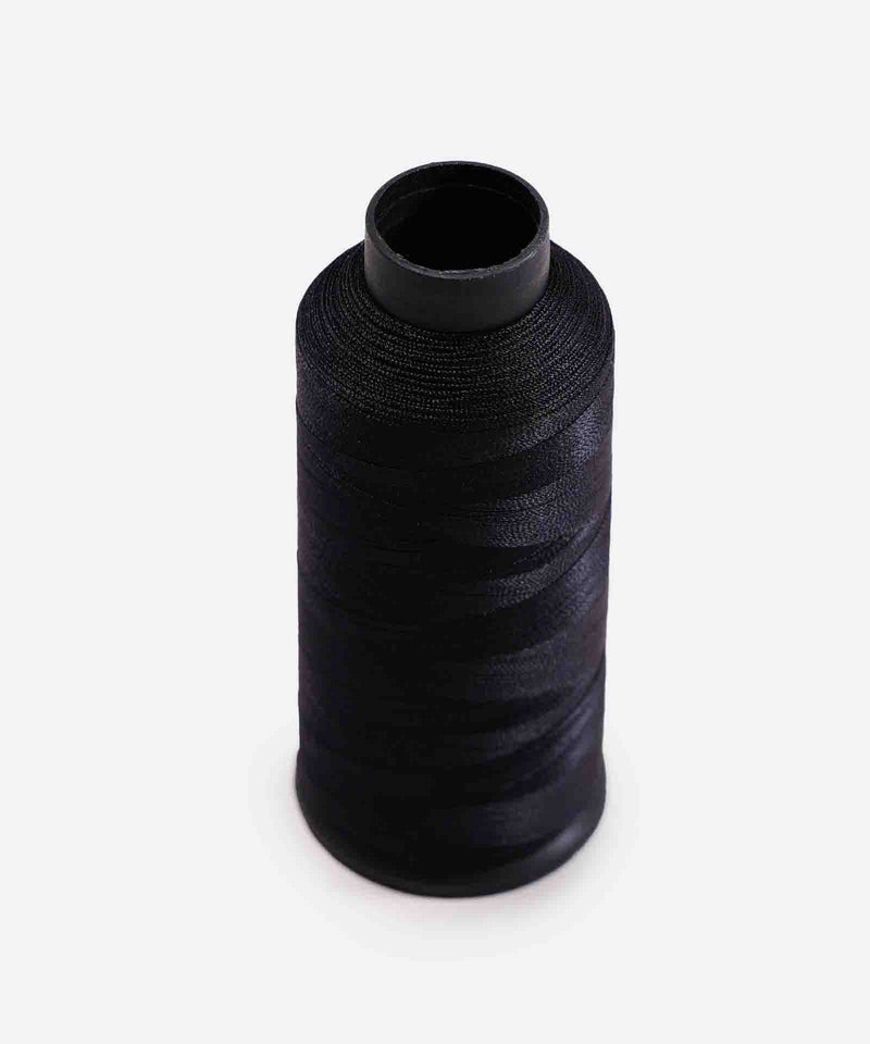 A spool of black sewing thread stands upright against a plain white background, ready for your next crafting project.