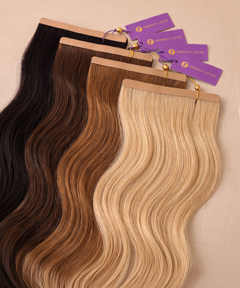 Four seamless tape-in weft hair extension packs in black, dark brown, auburn brown, and blonde with Perfect Locks tags