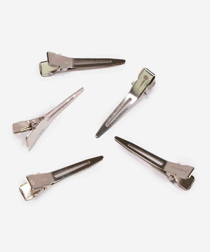 Five silver metal hair clips arranged on a white background, each clip open with visible hinges and textured, ridged edges for grip.