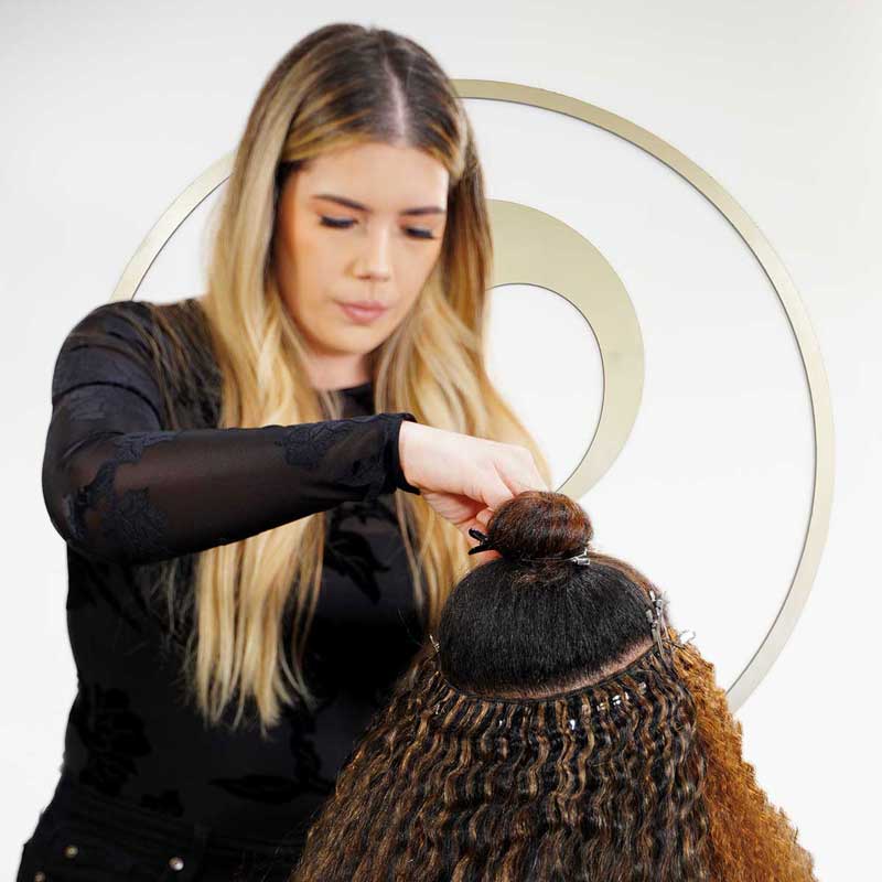 hair stylist installing weave