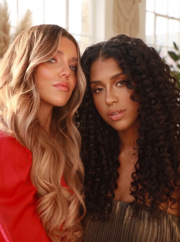 Two women with long hair extensions, one in soft blonde waves and one in dark brown curls