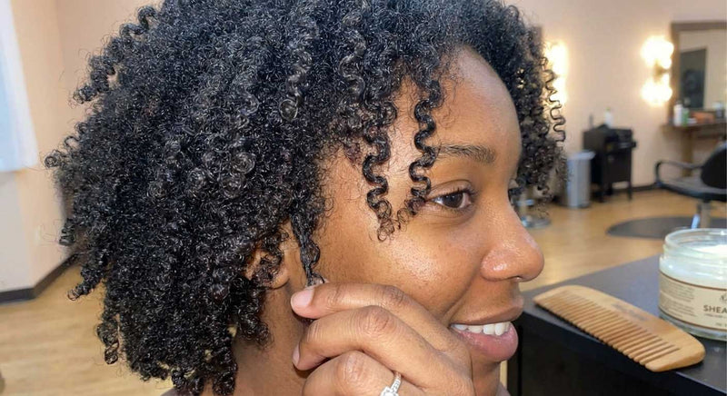 Woman with styled 4c hair in a salon setting