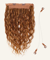 Curly Perfect Crown Hair Extensions by Perfect Locks with long, wavy toffee blonde hair and clip-in top next to a clear headband.#color_toffee-blonde-highlights-(4/27)