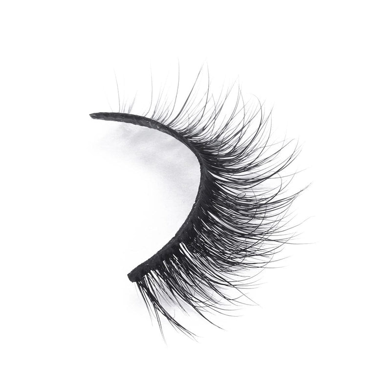 A single strip of black false eyelashes with thick, long, wispy fibers and a natural curl enhances the lash line on white background.