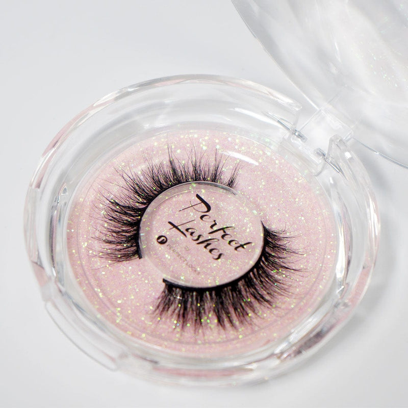 Presented in a round, clear plastic case with a glittery pink background, dramatic mink false eyelashes labeled Perfect Lashes.