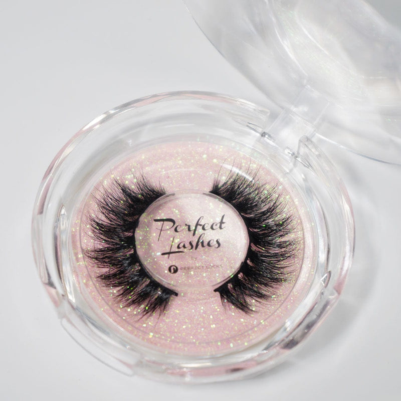 A pair of dramatic black false eyelashes in a round clear case with pink glittery background; label reads Perfect Lashes.