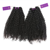 Two bundles of luscious, black curly hair extensions with purple bands and “Perfect Locks” tags attached for a high-quality look.