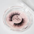 Dramatic, black false eyelashes in a round, clear plastic case with a pink glittery background and Perfect Lashes label inside.