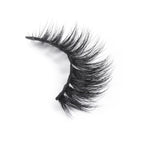 A single, curved strip of voluminous, black false eyelashes rests on a white background.