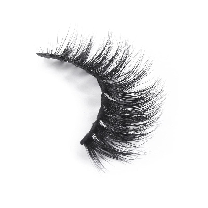A single, curved strip of voluminous, black false eyelashes rests on a white background.