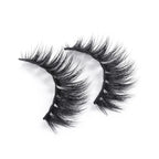 Two black, voluminous mink-effect false eyelashes with a dramatic, wispy texture are displayed on a white background.