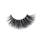 A single, curved strip of thick, black faux mink eyelashes with long, wispy fibers rests isolated on a white background.