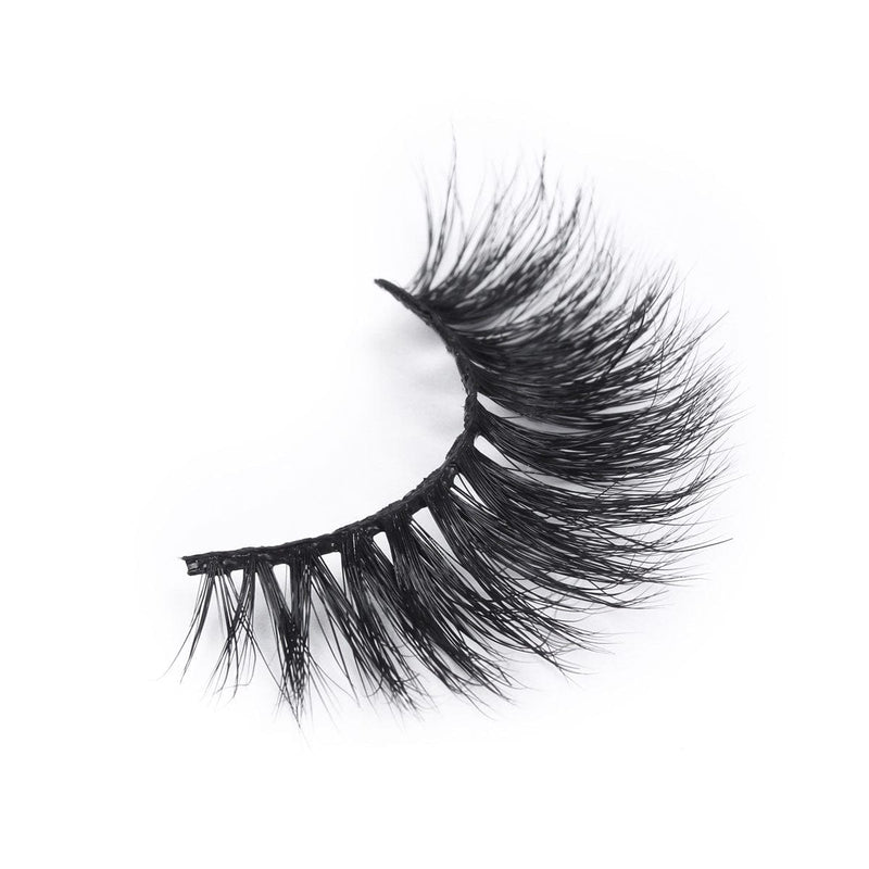 A single false eyelash with thick, long, and wispy black fibers, curved for a dramatic look, displayed on a white background.