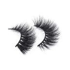 A pair of dramatic, black, faux mink false eyelashes with thick, fluffy, wispy fibers in a curved shape on a white background.