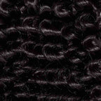 Shiny, tightly coiled black curls are highlighted in close-up, revealing the detailed texture and natural sheen of healthy curly hair.