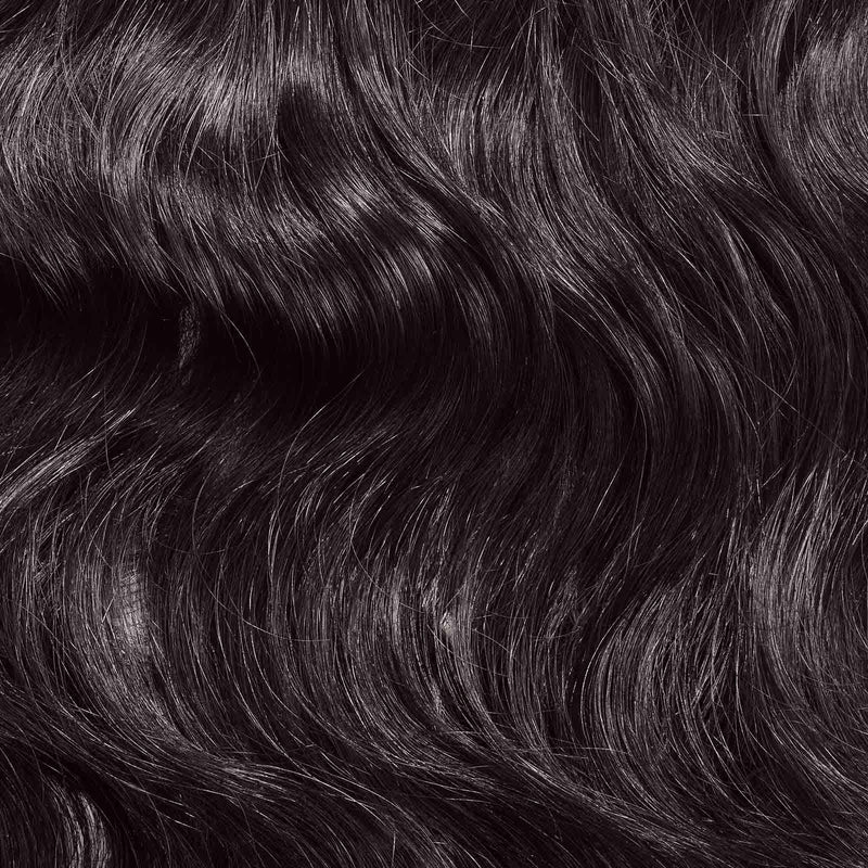 Close-up of long, wavy, dark brown or black hair with a shiny, healthy texture and well-defined natural waves and brunette tones.